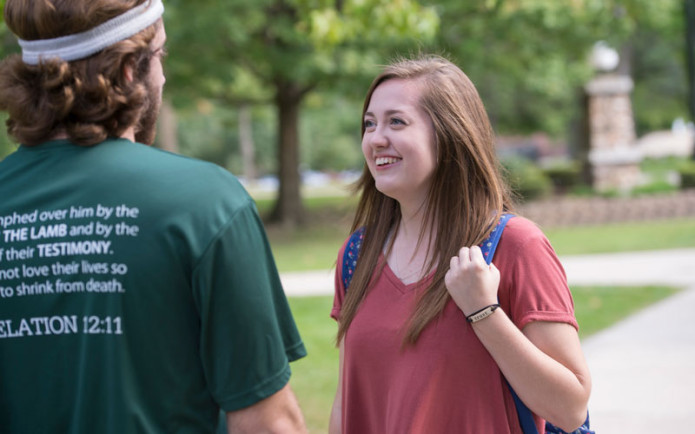 Two HU students are talking on campus.