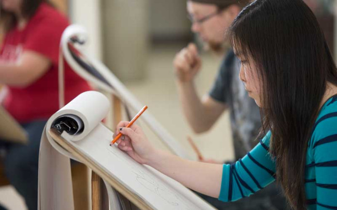 Two HU students drawing on a canvas.