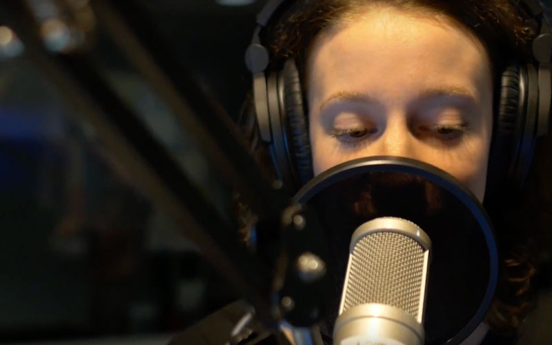 A student speaking into a microphone at Huntington University Radio.