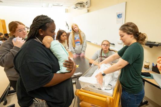 5 summer nursing camp students learn about infant health from an HU instructor.