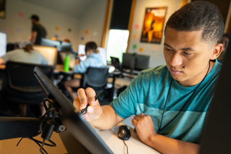 An animation student works on a graphic tablet.