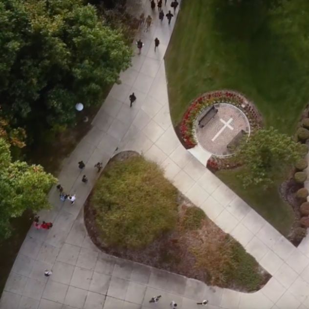 Image of Huntington University campus showing students walking along paths. 