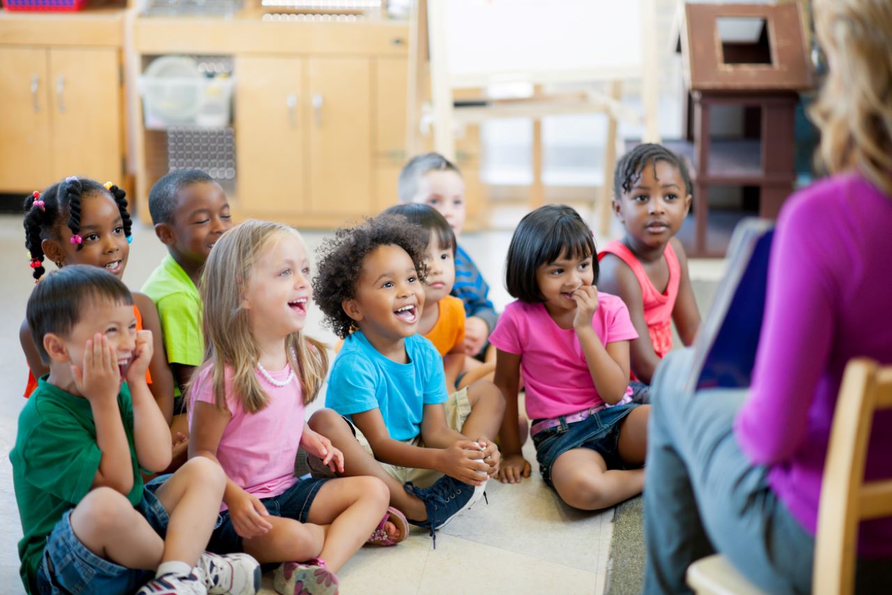 Little kids listening to a teacher.