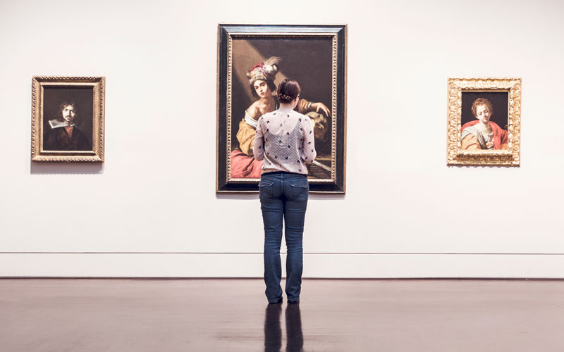 HU student admiring paintings and drawings.